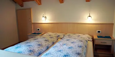 a bedroom with a bed and two lights on the wall at Wirthof in La Valle