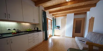 a kitchen with white cabinets and a couch in a room at Wirthof in La Valle