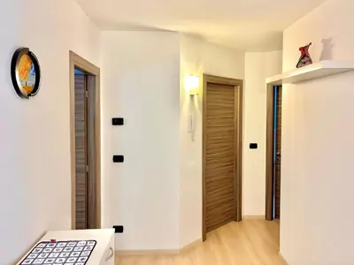 a room with white walls and a room with a door at Appartamento vicino agli impianti Predazzo in Predazzo