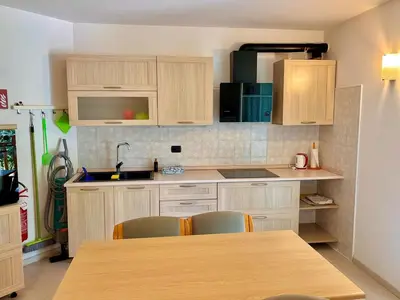 a kitchen with wooden cabinets and a table with chairs at Appartamento vicino agli impianti Predazzo in Predazzo