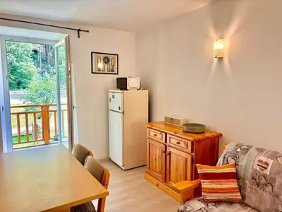 a living room with a table and a refrigerator at Appartamento vicino agli impianti Predazzo in Predazzo