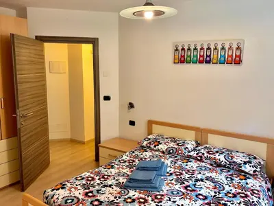 a bedroom with a bed with a colorful comforter at Appartamento vicino agli impianti Predazzo in Predazzo