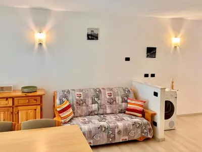 a living room with a couch and a microwave at Appartamento vicino agli impianti Predazzo in Predazzo