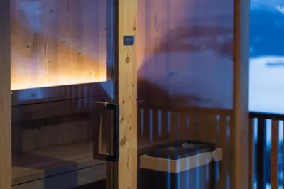 a wooden door with a trash can next to it at Oachner Living in Feldthurns