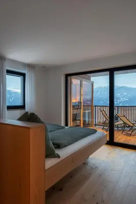 a bedroom with a bed with a view of a balcony at Oachner Living in Feldthurns