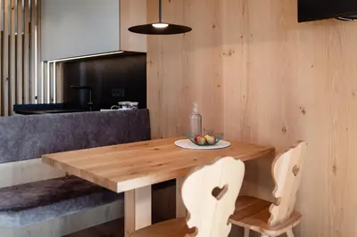 a wooden table in a kitchen with two chairs at Oachner Living in Feldthurns