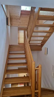 a wooden staircase in a room with a window at Ciasa Rungger in San Martino in Badia