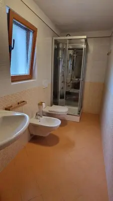 a bathroom with two sinks and a shower and a toilet at Ciasa Rungger in San Martino in Badia