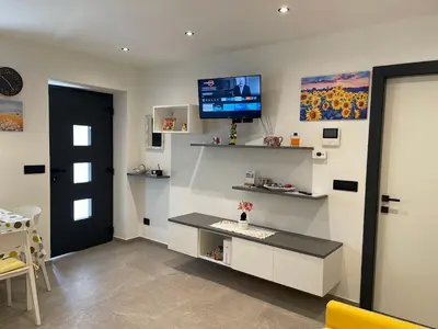 a living room with a tv on the wall at Appartamento Pineta casa vacanze Sci & Natura in Varena