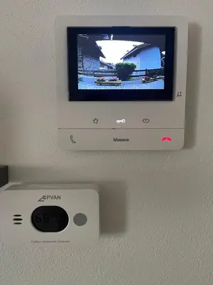 a television on a wall with a remote control at Appartamento Pineta casa vacanze Sci & Natura in Varena
