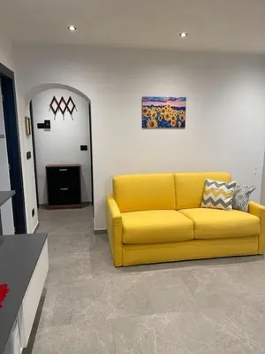 a yellow couch sitting in a living room at Appartamento Pineta casa vacanze Sci & Natura in Varena