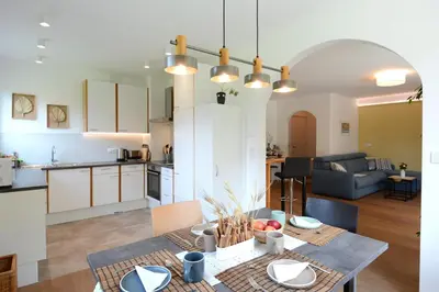 a kitchen and living room with a table in a room at maia garden - apartment & private garden in Merano