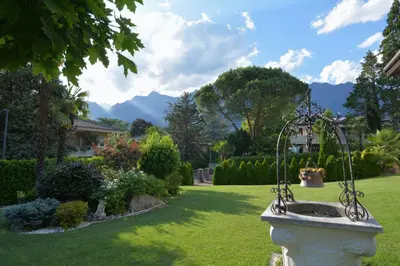 a fountain in a yard with mountains in the background at maia garden - apartment & private garden in Merano