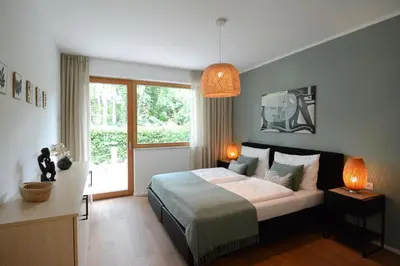 a bedroom with a bed and a large window at maia garden - apartment & private garden in Merano