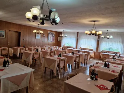 a dining room filled with tables with white tablecloths at Albergo Passione Ristorante Pizzeria Romallo in Romallo