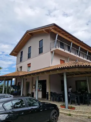 a building with a car parked in front of it at Albergo Passione Ristorante Pizzeria Romallo in Romallo