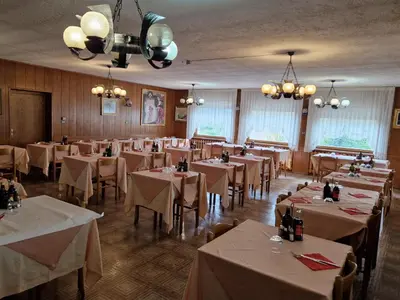 a dining room with tables and chairs with white table cloth at Albergo Passione Ristorante Pizzeria Romallo in Romallo