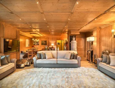 a living room with a couch and a table at Elegant Tablà with Garden R&R in Cortina dʼAmpezzo
