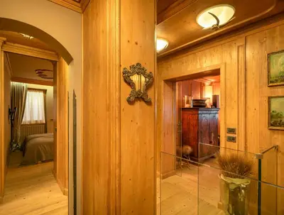a hallway of a house with a room with a bed at Elegant Tablà with Garden R&R in Cortina dʼAmpezzo