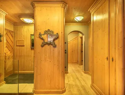 a hallway with wooden walls and a wooden door at Elegant Tablà with Garden R&R in Cortina dʼAmpezzo