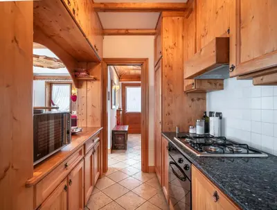 a kitchen with wooden cabinets and a stove at Verocai Charming Chalet R&R in Cortina dʼAmpezzo