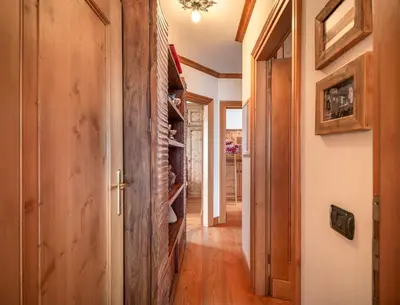 a hallway with a stone wall in a house at Verocai Charming Chalet R&R in Cortina dʼAmpezzo