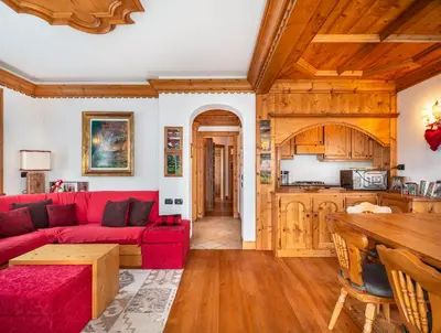 a living room with a red couch and a table at Verocai Charming Chalet R&R in Cortina dʼAmpezzo