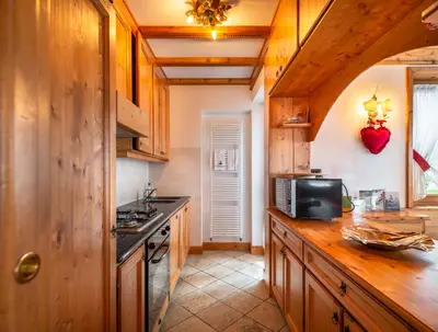 a kitchen with wooden cabinets and a counter top at Verocai Charming Chalet R&R in Cortina dʼAmpezzo