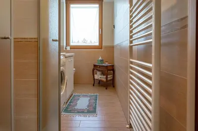 a bathroom with a washing machine and a window at Dimora Kino, Taio Ospitar in Taio