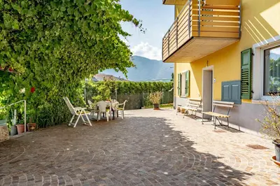 a patio of a house with a table and chairs at Dimora Kino, Taio Ospitar in Taio