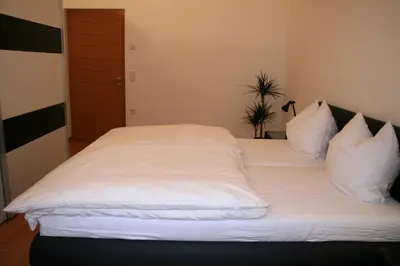 a large bed with white sheets and pillows at Kreuzsteinhof in San Paolo