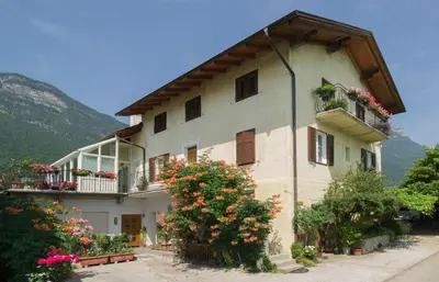 a building with flowers and plants in front of it at Gästehaus Zugal in Caldaro