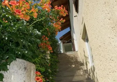 a stairway with flowers on the side of a building at Gästehaus Zugal in Caldaro