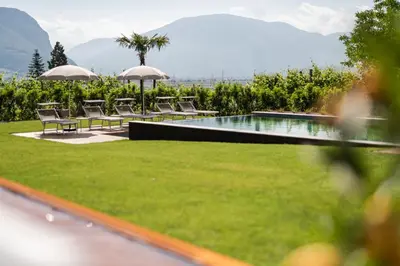 a garden with chairs and a swimming pool at Hotel Garni Sonngart in Andrian