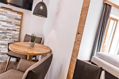 a dining room with a wooden table and chairs at Hotel Garni Sonngart in Andrian