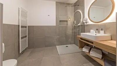 a bathroom with a sink and a toilet and a mirror at Hotel Garni Sonngart in Andrian