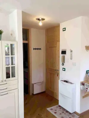 a kitchen with a white refrigerator and a door at Riccarden Cavalese Centro in Cavalese