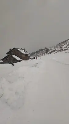 a group of people standing in the snow next to buildings at Riccarden Cavalese Centro in Cavalese