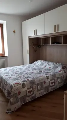 a bedroom with a bed with a blanket on it at Riccarden Cavalese Centro in Cavalese