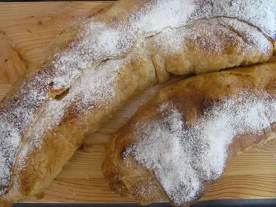 two pieces of bread with powdered sugar on a cutting board at NonSoloMele in Romallo
