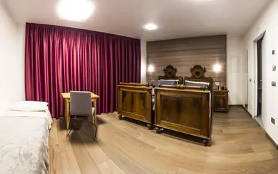 a hotel room with a bed and a red curtain at NonSoloMele in Romallo