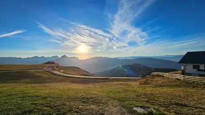 a house on a hill with the sun in the sky at Panorama Dolomiti in San Vigilio Di Marebbe