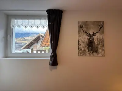 a picture of a deer on the wall next to a window at Casa dei BROCA - Cavalese Val di Fiemme in Cavalese