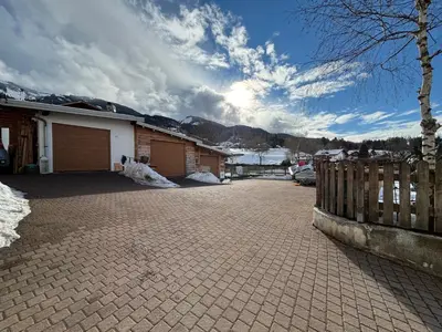 a house with a fence and a brick driveway at Casa dei BROCA - Cavalese Val di Fiemme in Cavalese