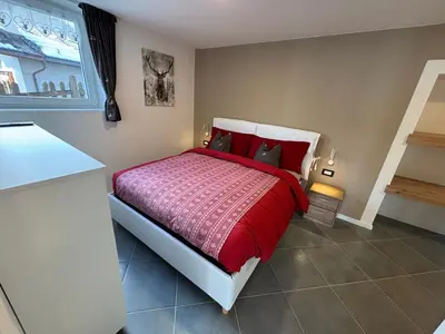 two beds with red pillows in a room at Casa dei BROCA - Cavalese Val di Fiemme in Cavalese