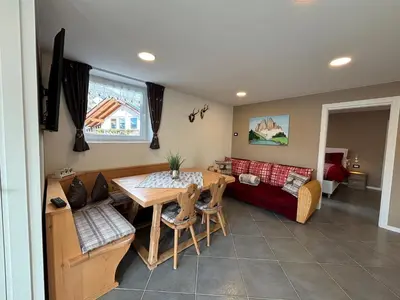 a living room with a red couch and a table at Casa dei BROCA - Cavalese Val di Fiemme in Cavalese