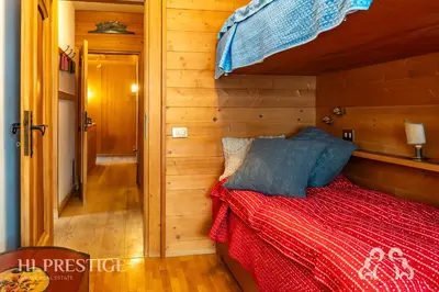 a bedroom with a bed and a chair and a window at Dolympic View Cortina in Cortina dʼAmpezzo