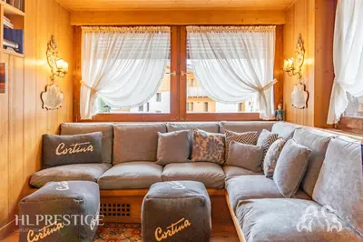 a room with a bed and a shelf with books at Dolympic View Cortina in Cortina dʼAmpezzo