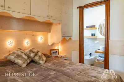 a bed with fur covered pillows on top of it at Cà di Bosco Cortina in Cortina dʼAmpezzo