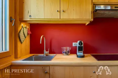 a kitchen with a sink and a red wall at Dimora del Corso Cortina in Cortina dʼAmpezzo